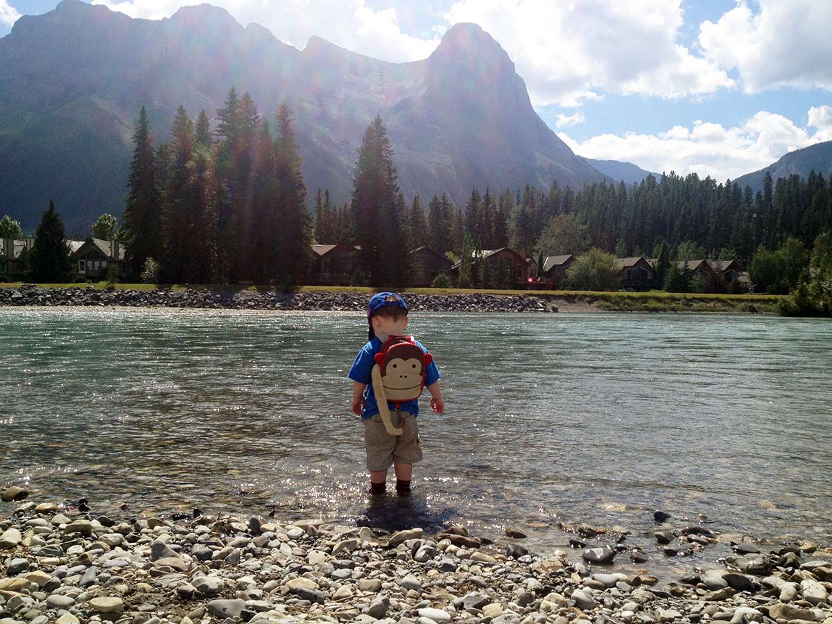 Throwing stones into the river on the Main Street, Bow River and the Rail Bridge Hike in Canmore, Alberta