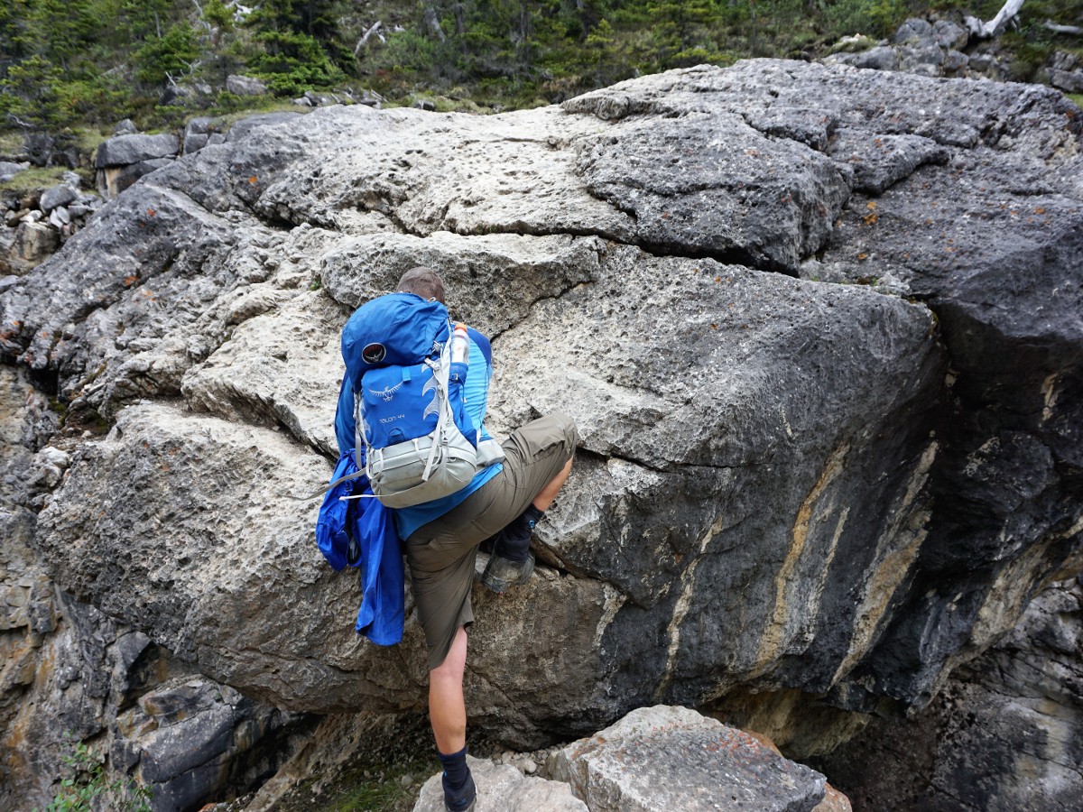 Scrambling over boulder Bridge on the Bow Hut Hike from Icefields Parkway in Banff National Park