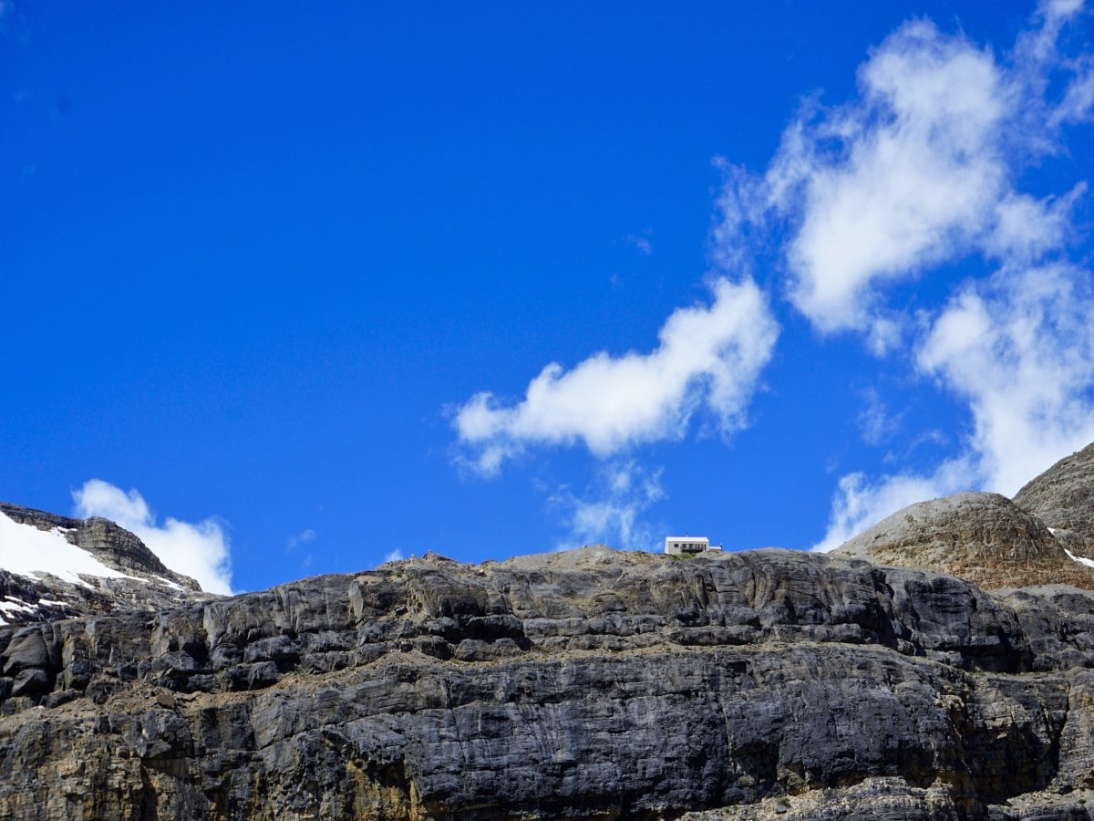 The view of Bow Hut on the rock ledge on the Bow Hut Hike from Icefields Parkway in Banff National Park