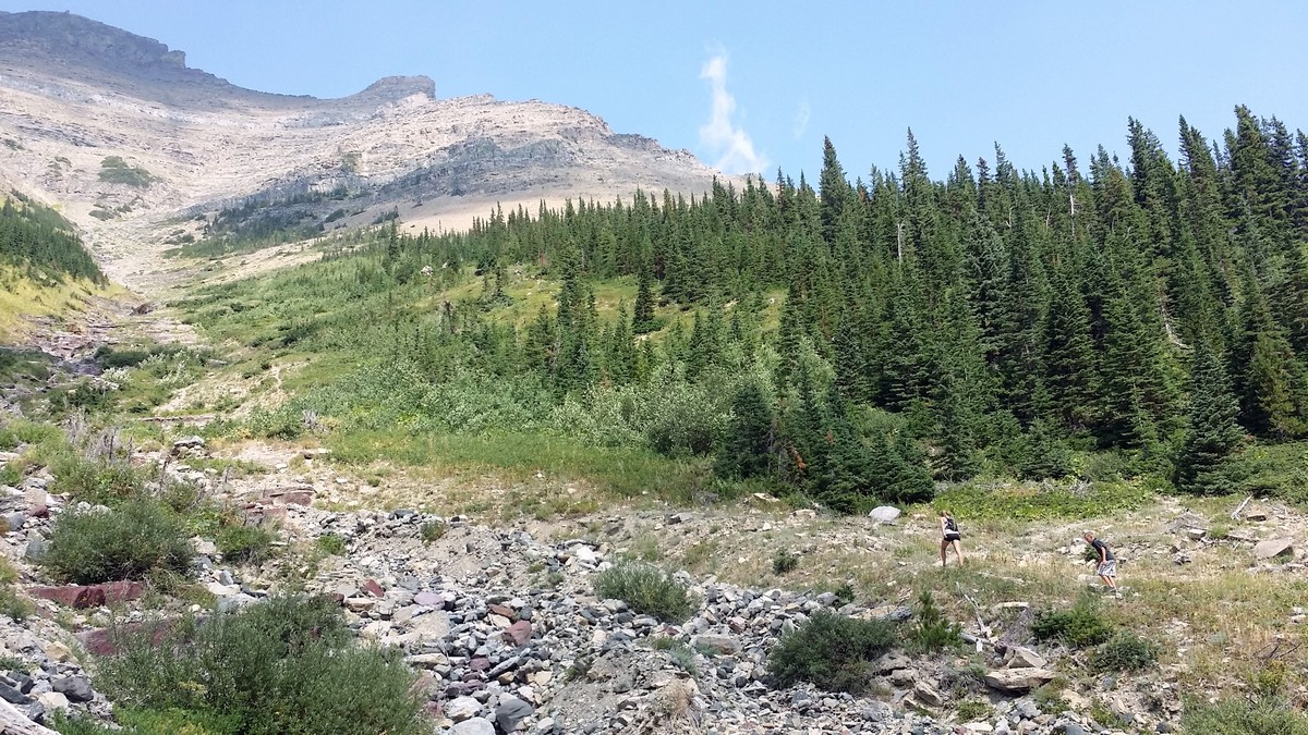 Hikers climbing along the avalanche chute on the Lineham Falls Hike in Waterton Lakes National Park, Canada