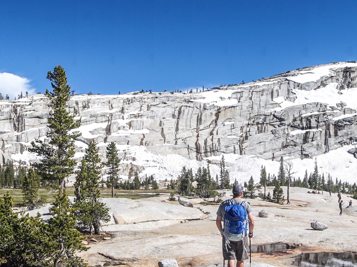 Man hiking near Cathedral Lakes with gear on his back in Yosemite