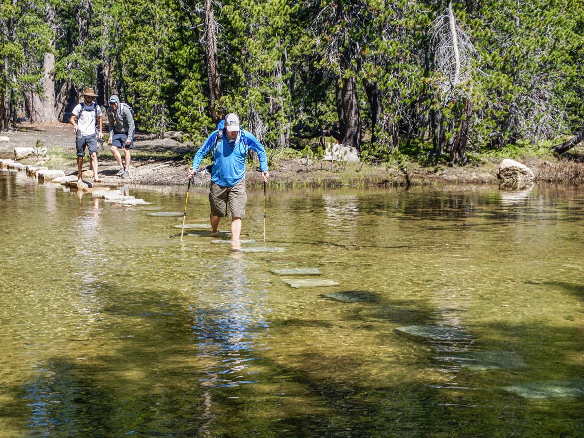 Men walking across the river at Clouds Rest Hike Yosemite National Park