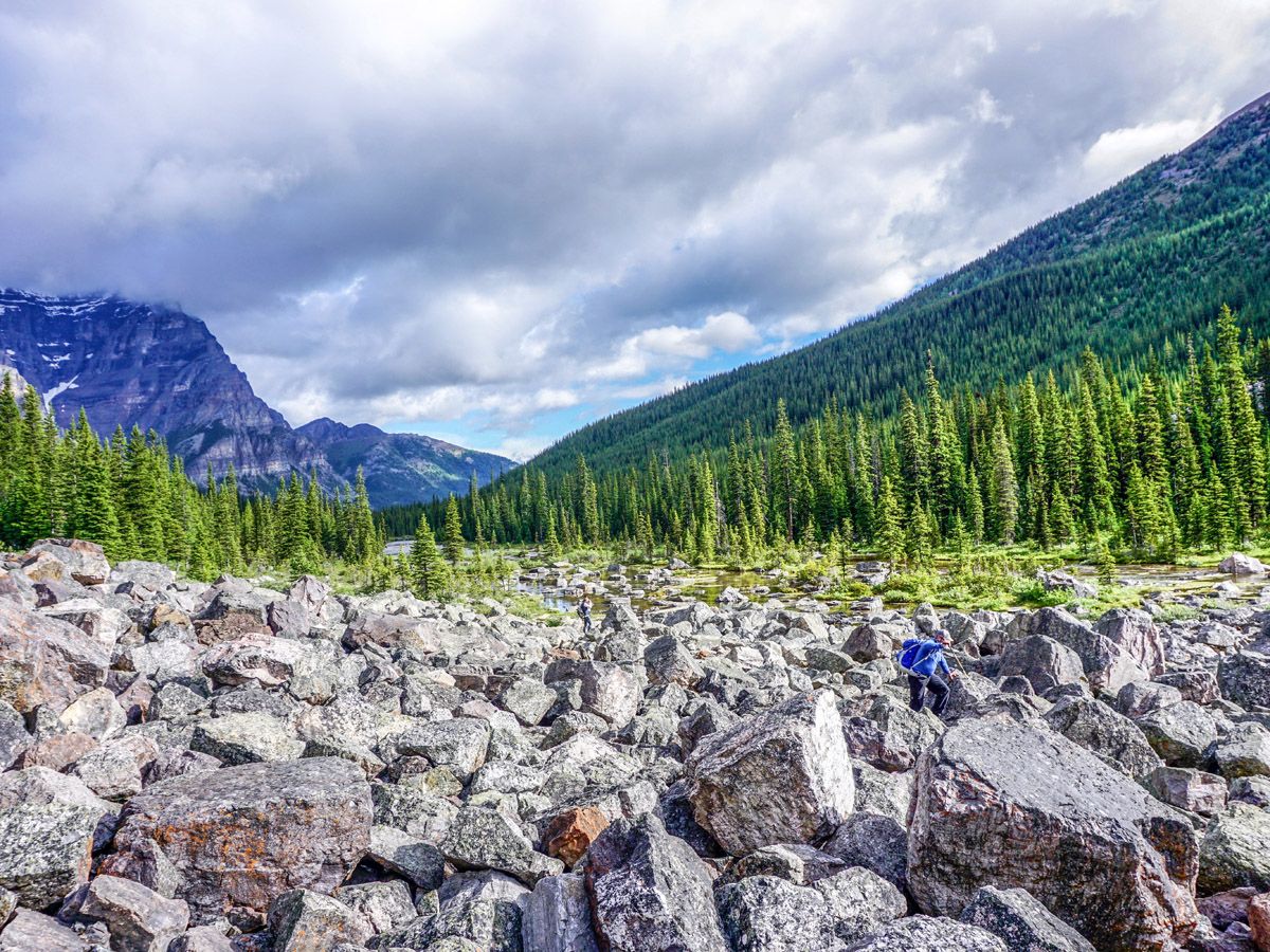 Man climbing over rocks on the Consolation Lakes Hike in Lake Louise, Banff National Park