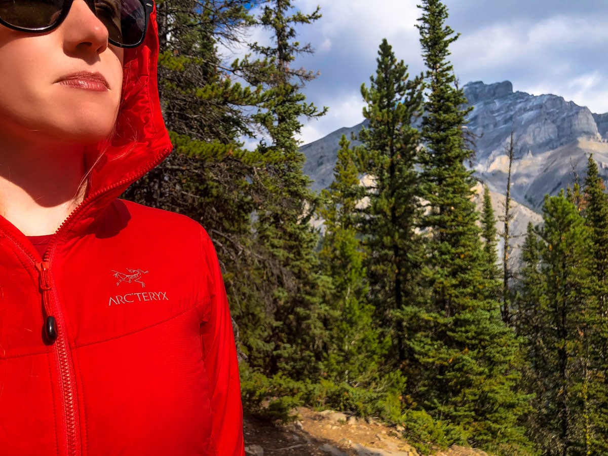 Hiker wearing Women's Atom LT Hoody in red