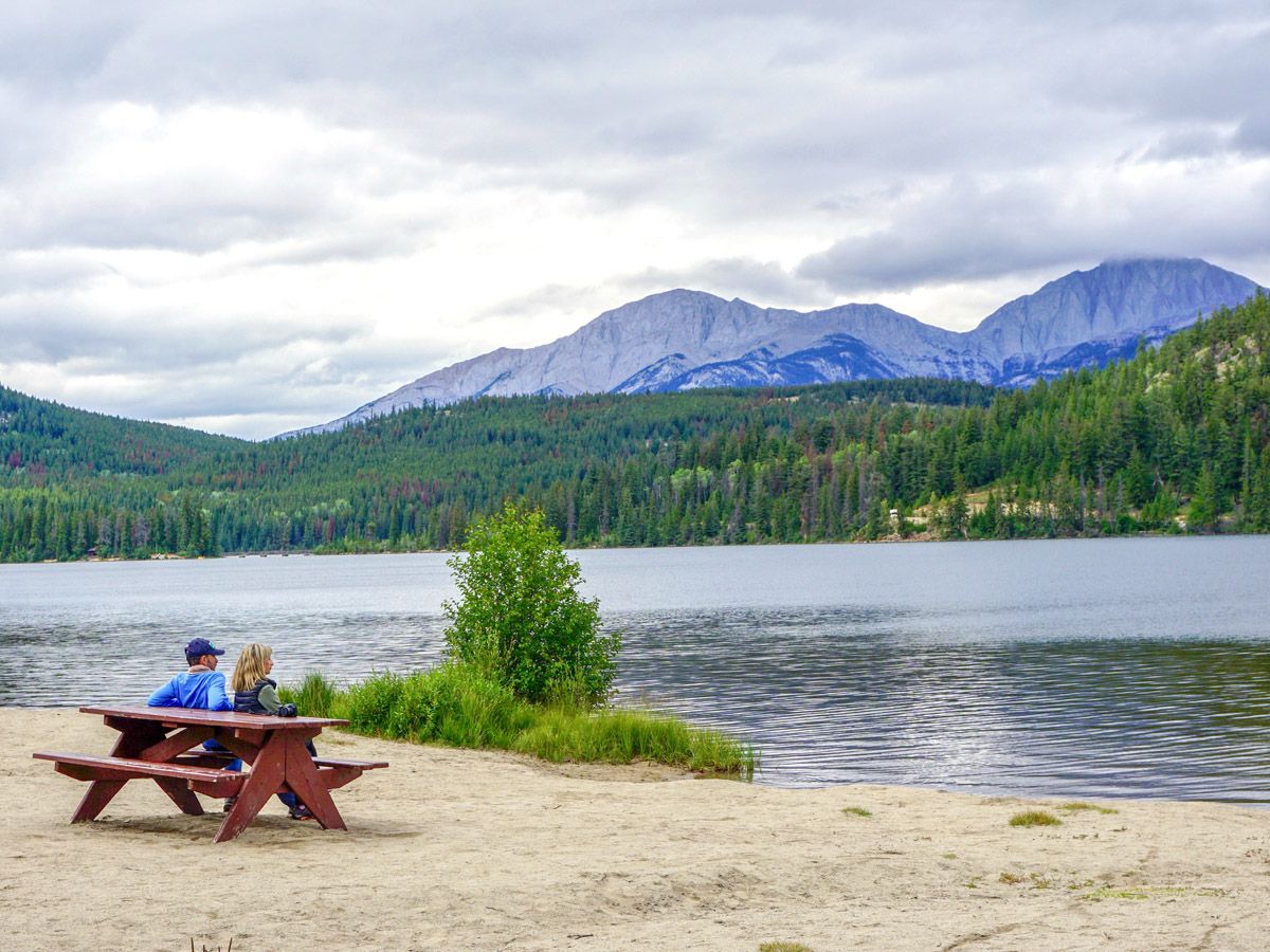 Couple resting on a bench on the Pyramid Lake Hike in Jasper National Park, Alberta