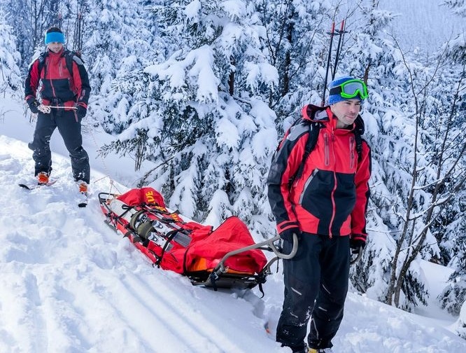 Ski patrol with sled helps to keep hikers safe in winter