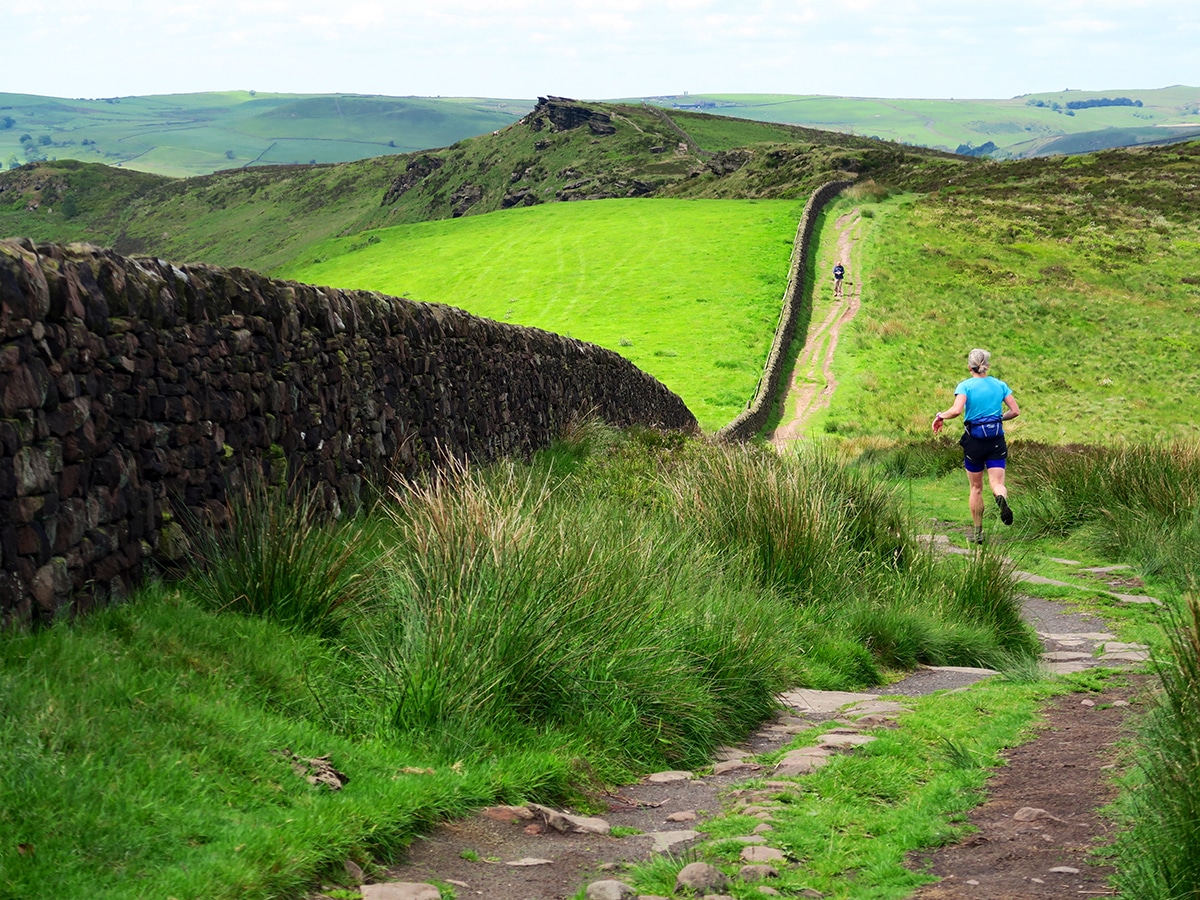 Fell runner on the footpath to Danesbridge on The Roaches and Lud's Church Hike in Peak District, England