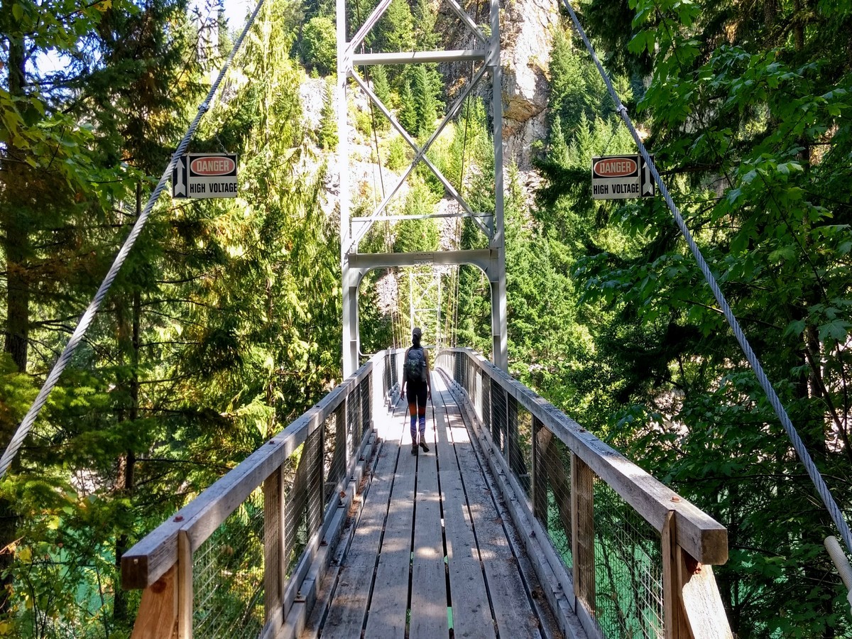 Hiking across the suspension bridge on the Diablo Lake Trail Hike in North Cascades National Park, Washington