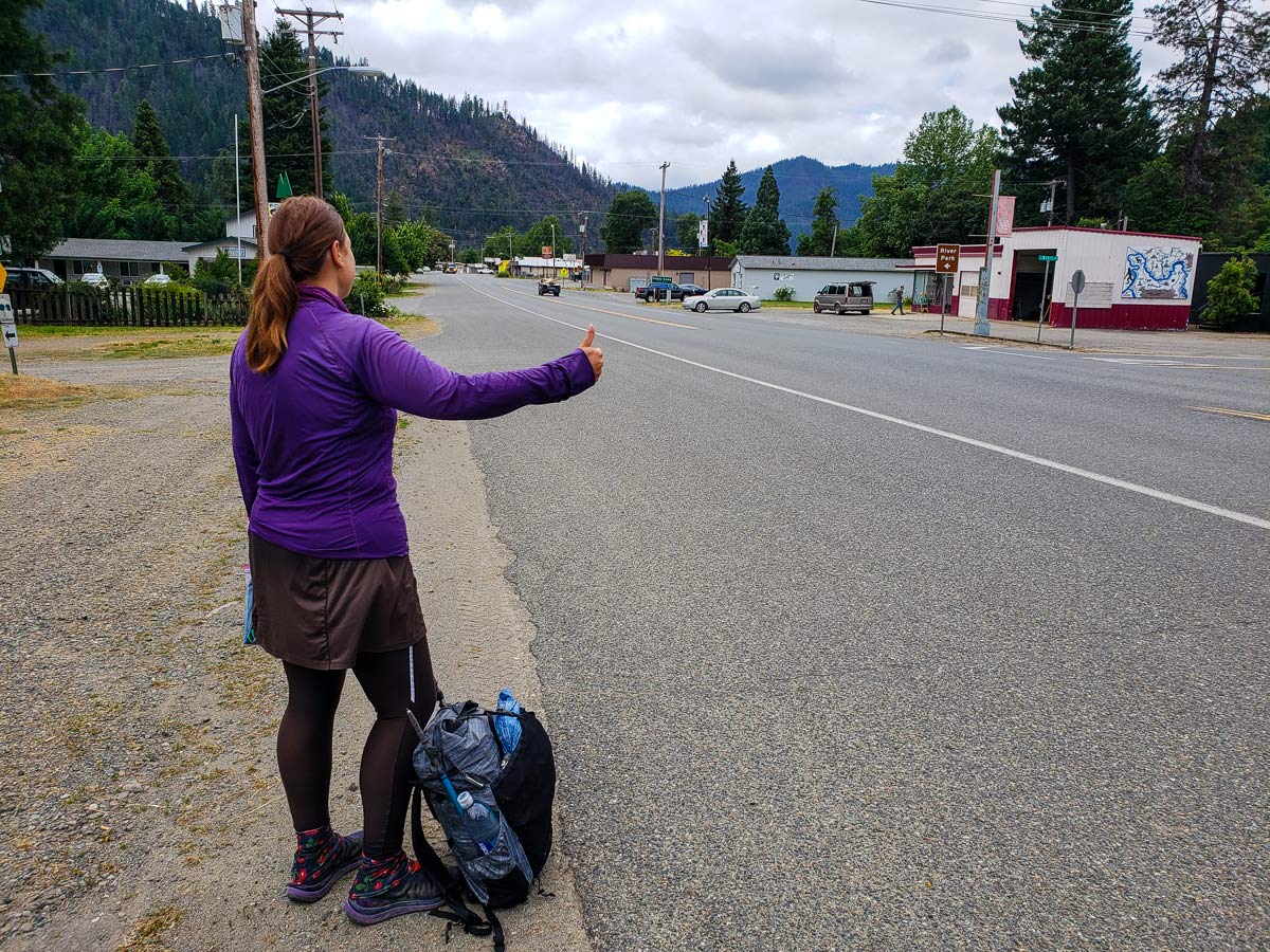 Hiker hitchhiking on the side of the road on the Pacific Crest Trail