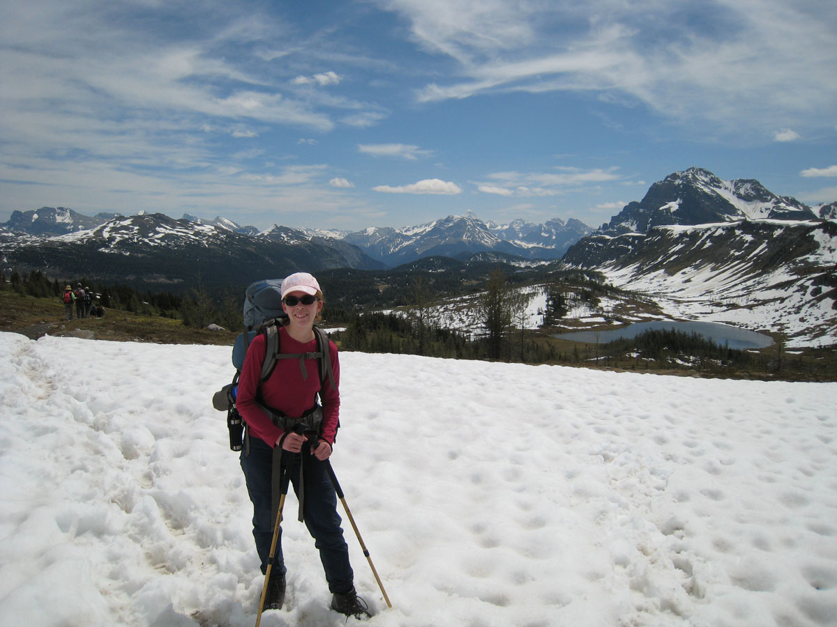 Lady hiking on snow on Egypt Lake backpacking trail in Banff National Park