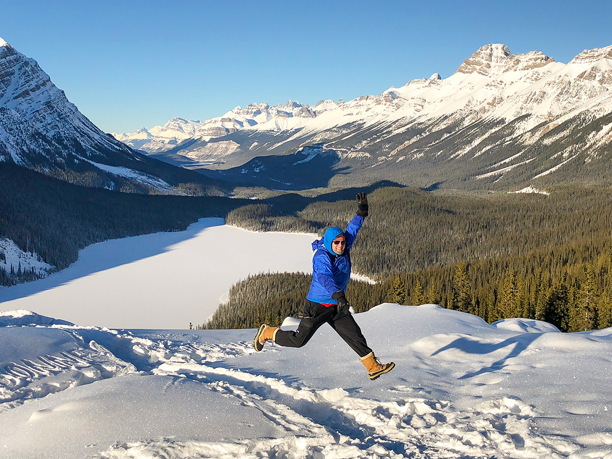 Lady enjoying the snow on Peyto Lake Viewpoint snowshoe trail in Banff National Park