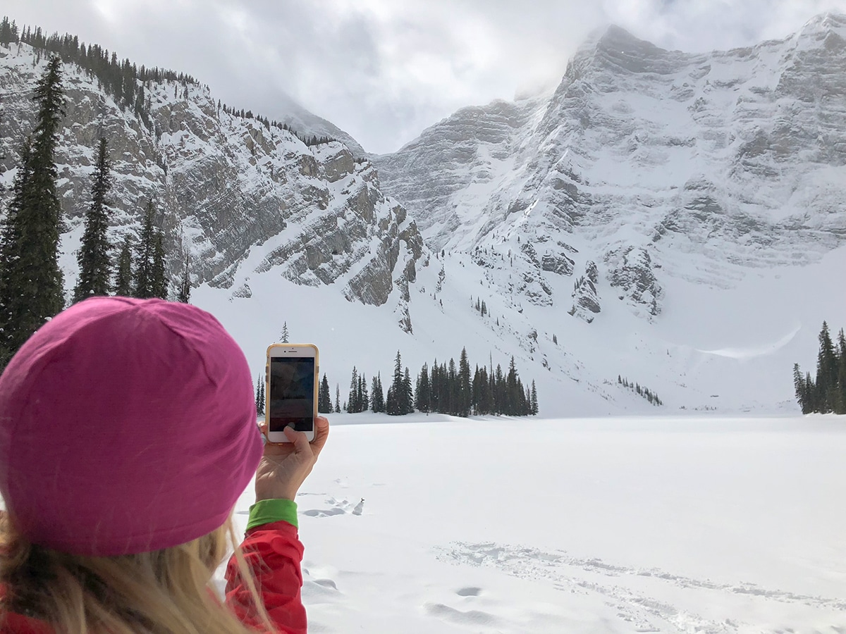 Taking pictures on Rawson Lake snowshoe trail in Kananaskis near Canmore