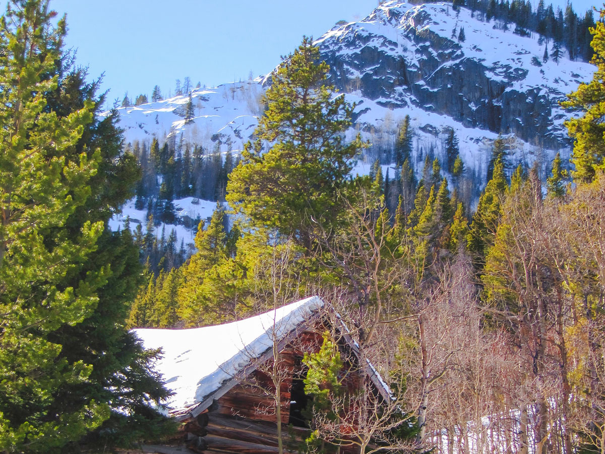Cabin covered by snow on Hessie snowshoe trail in Indian Peaks, Colorado