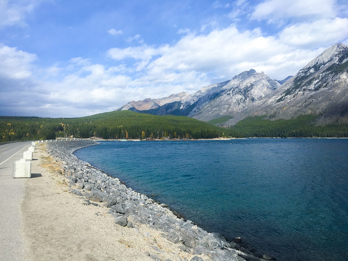 Crossing the causeway beside the lake on Minnewanka Loop road biking route in Banff National Park
