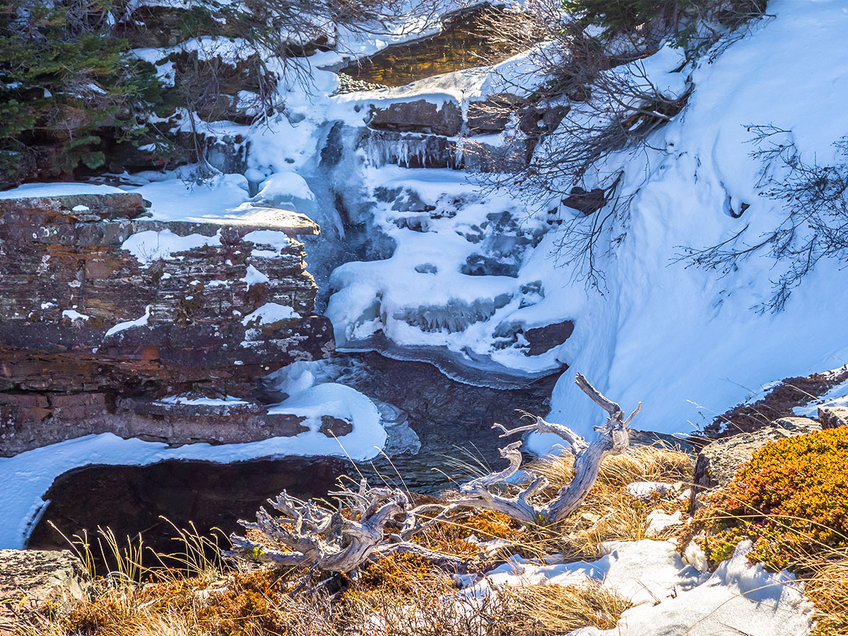 Partially frozen waterfall on Pincher Creek on Victoria Peak scramble in Castle Provincial Park, Alberta