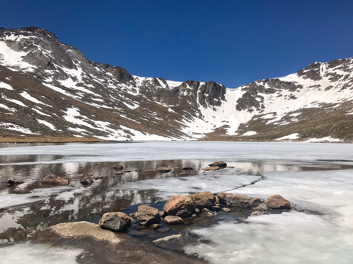 Lake getting covered by ice on Mount Evans hike in Denver, Colorado