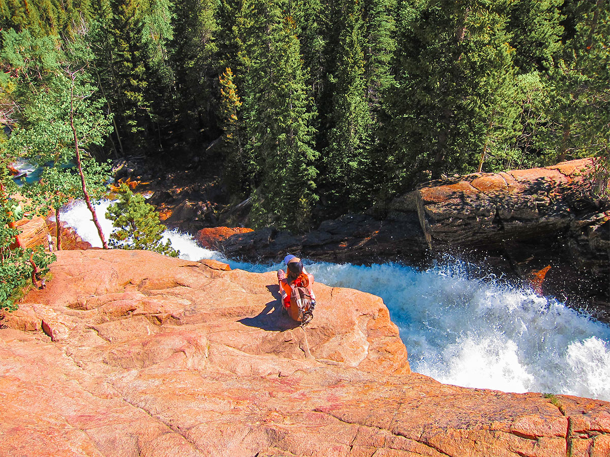 Hiker near the falls on Loch hike in Rocky Mountain National Park, Colorado