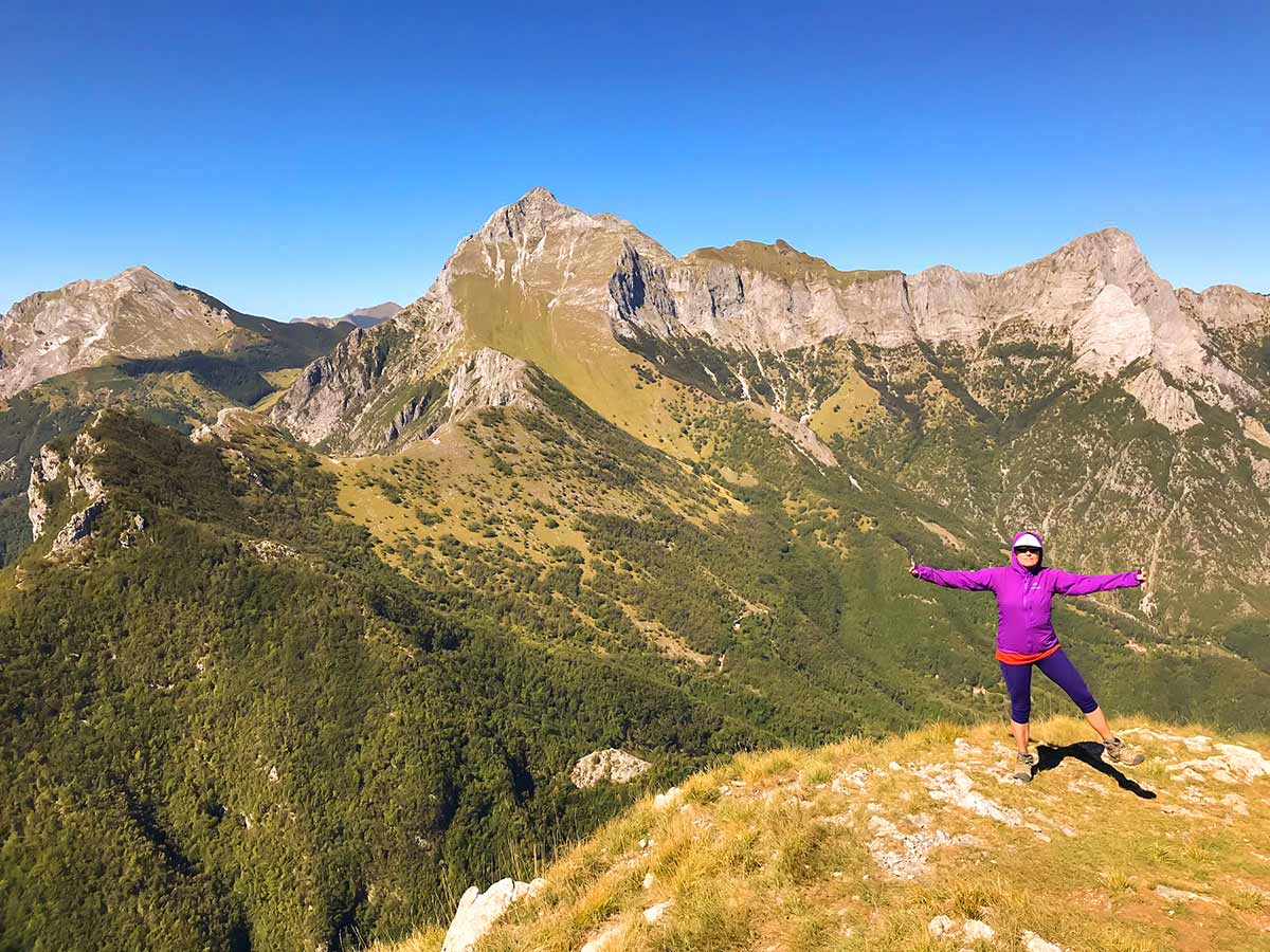 Hiker posing on top of Monte Croce Hike in Tuscany