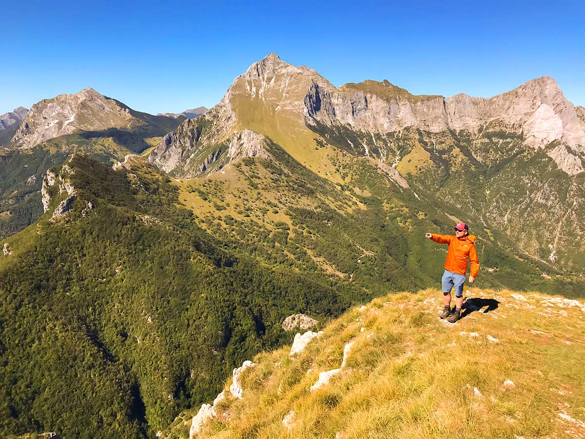 Biker posing among peaks on Monte Croce from Palagnana Hike in Tuscany