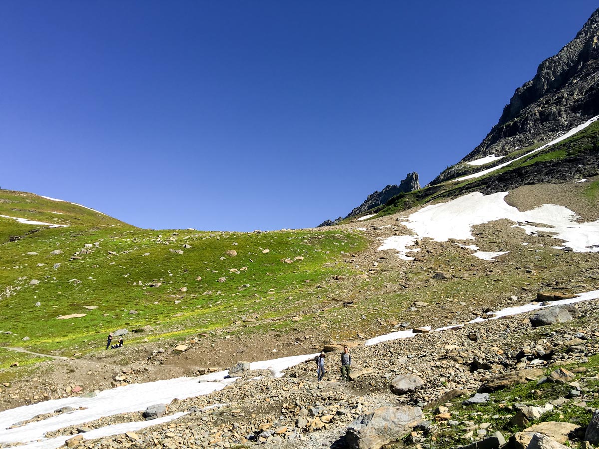 Hikers below Logan Pass on Highline backpacking trail in Glacier National Park, Montana