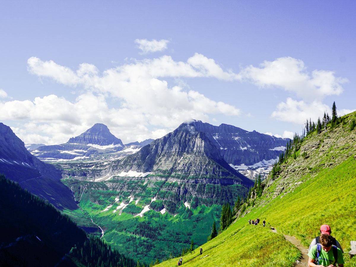 Hikers and beautiful valley views on Highline backpacking trail in Glacier National Park, Montana