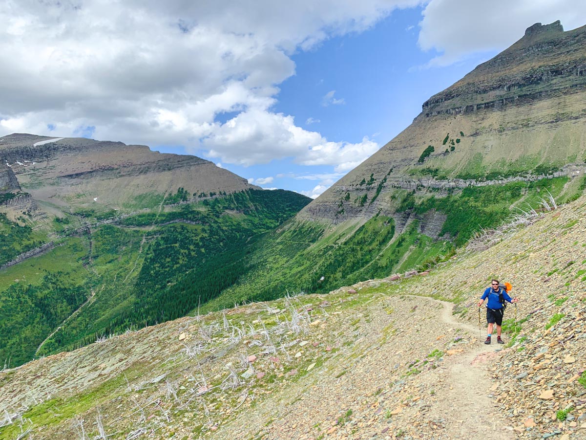 Hiker in front of incredible scenery on Highline backpacking trail in Glacier National Park, Montana