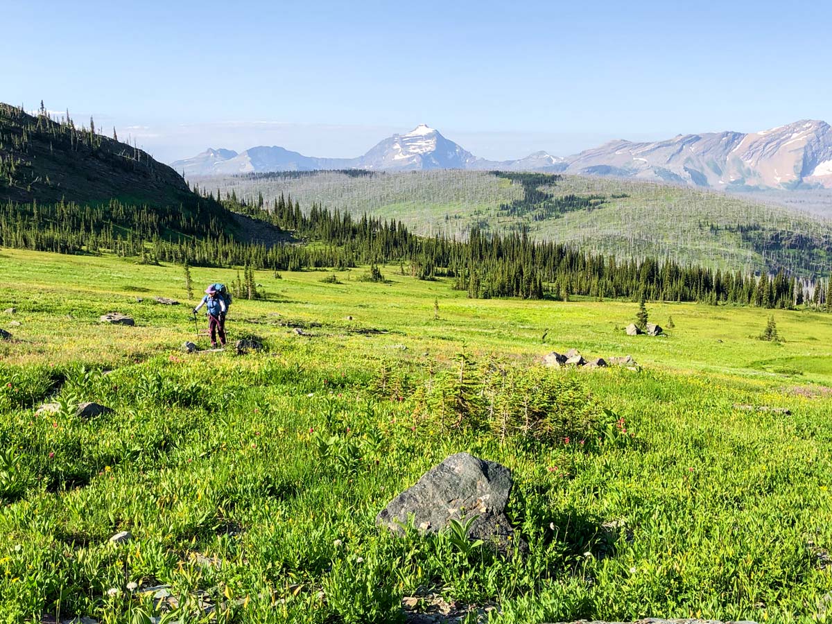Backpacker surrounded by beautiful views on Highline backpacking trail in Glacier National Park, Montana