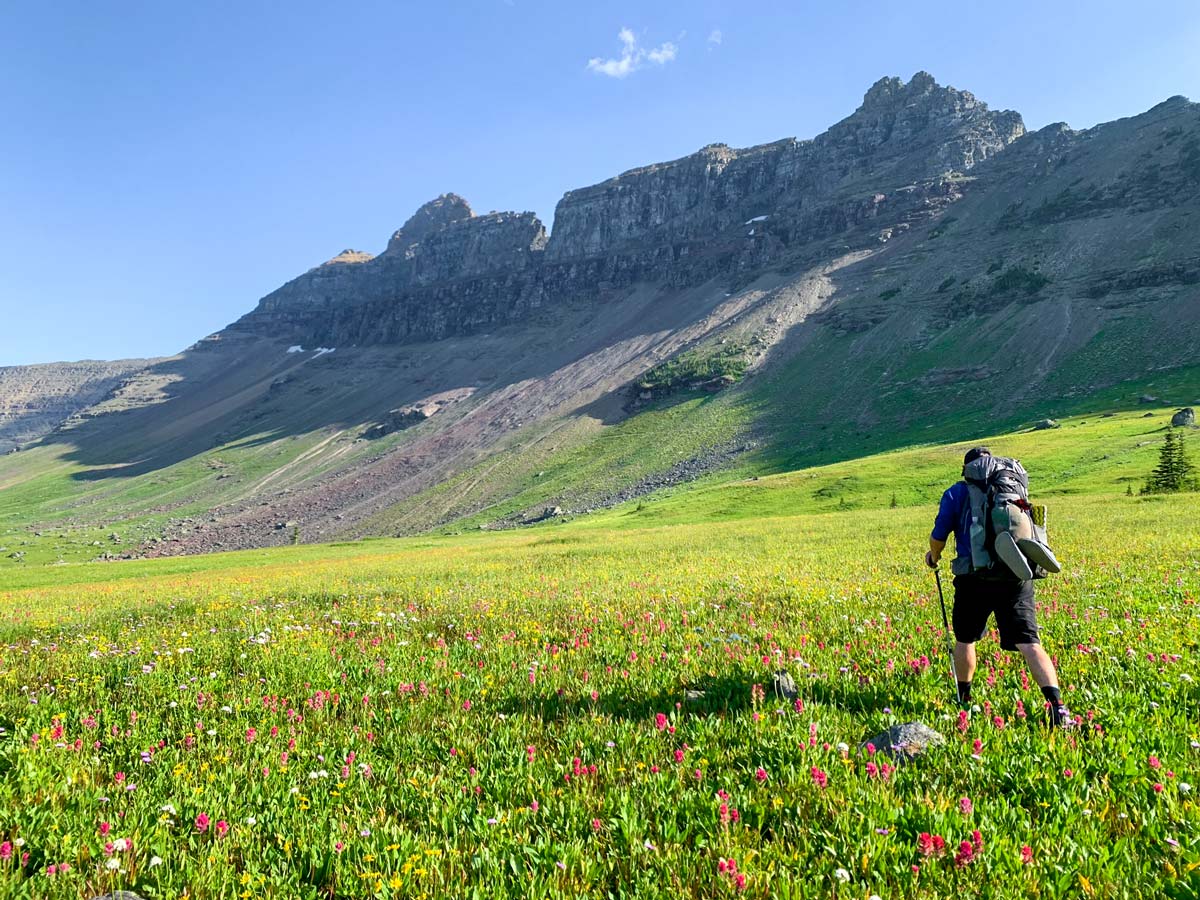 Backpacker hiking on Highline backpacking trail in Glacier National Park, Montana