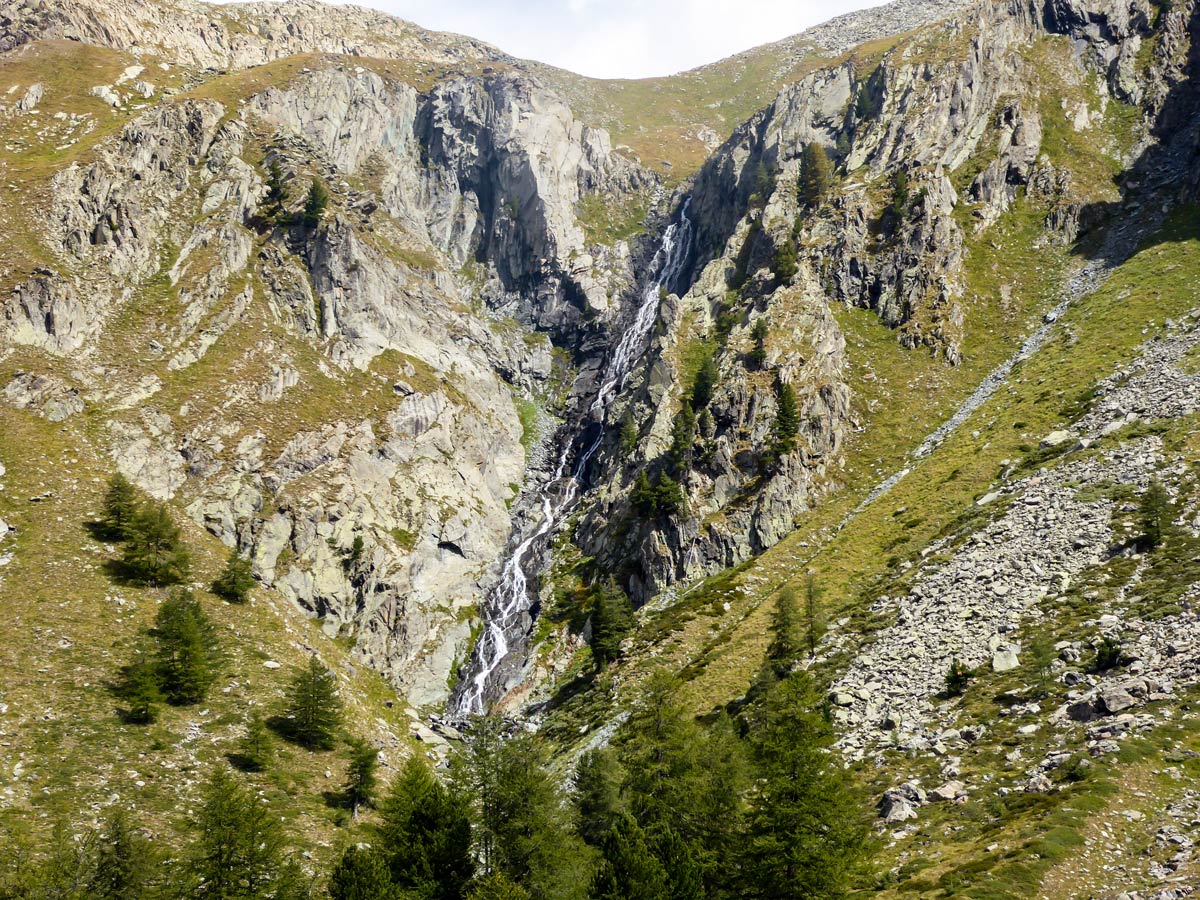 Scenic waterfall on Lago di Loie hike in Gran Paradiso National Park, Italy