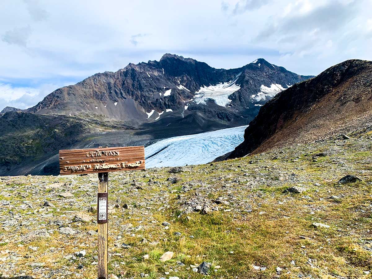 Sign on Crow Pass Trail looking towards Raven Glacier in Chugach State Park Alaska