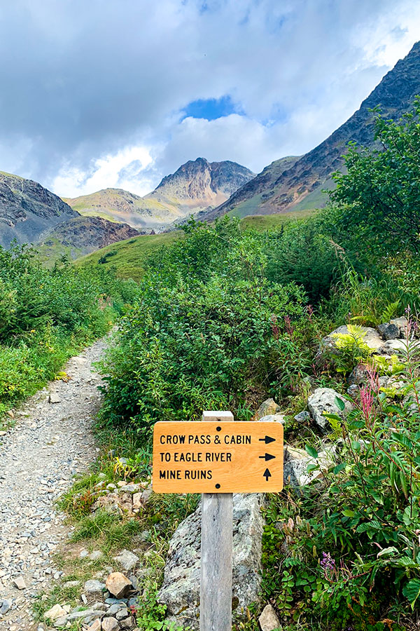 Sign pointing to Crow Pass on a trail to Raven Glacier Alaska