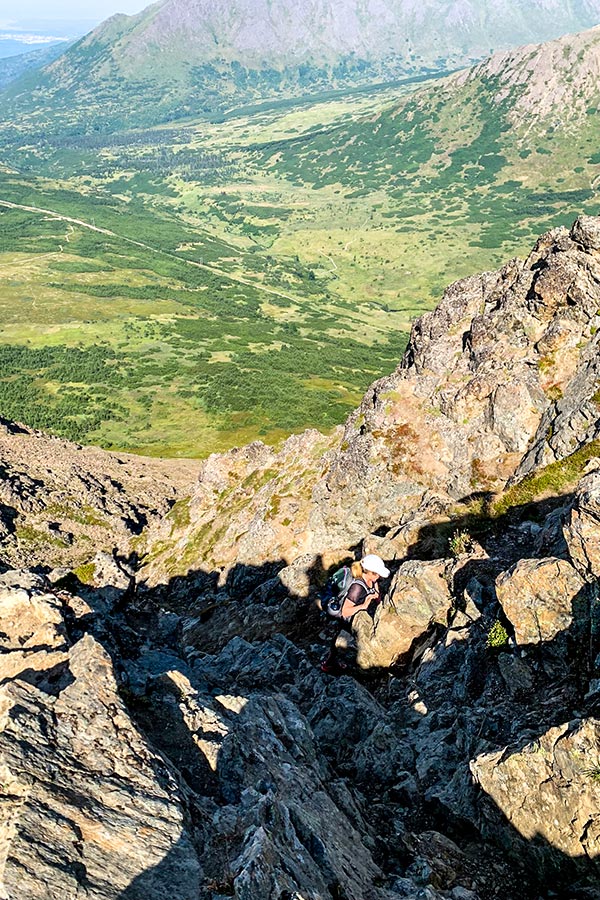 Hiker on a scrambly part of Flattop Mountain Trail near Anchorage Alaska