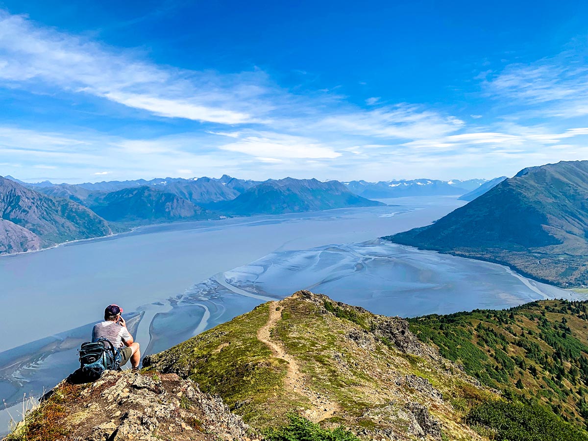 Hiker resting on Hope Point Trail with beautful views of Turnagain Arm in Alaska