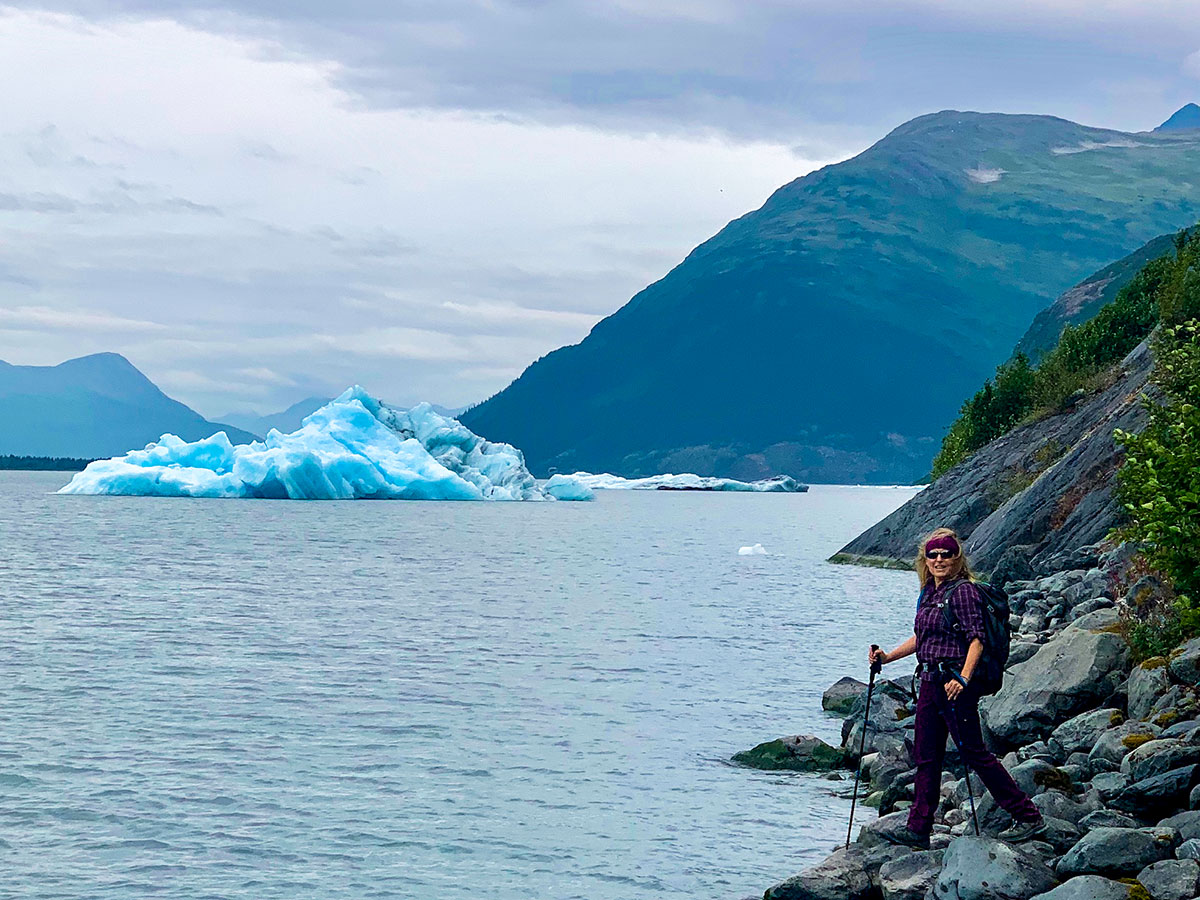 Hiker posing near Iceberg in Portage Lake on a hike through Portage Pass Trail