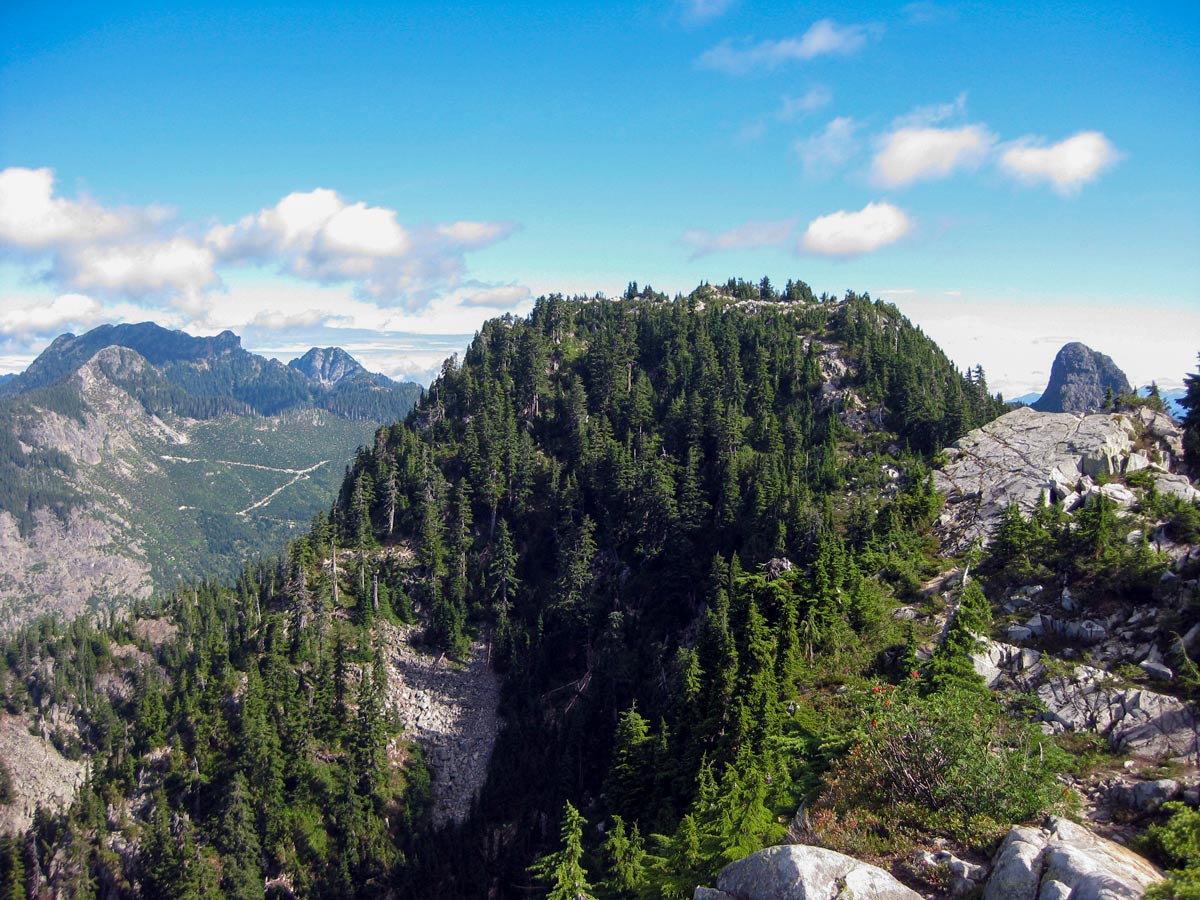 Hiker climbs the rocks of Howe Sound Crest Trial in North Shore region of coastal BC