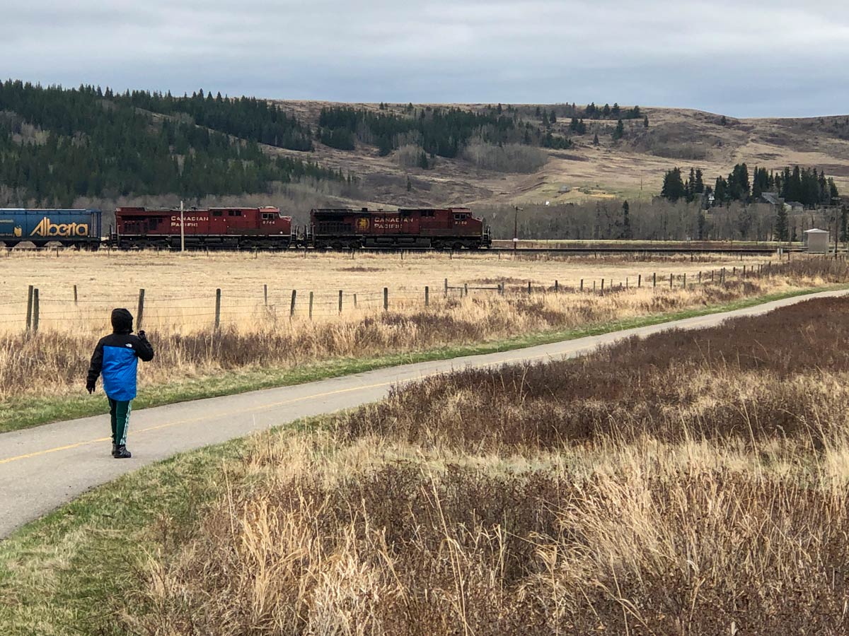 Boy watches trains at Glenbow Ranche walking paths near Calgary Alberta