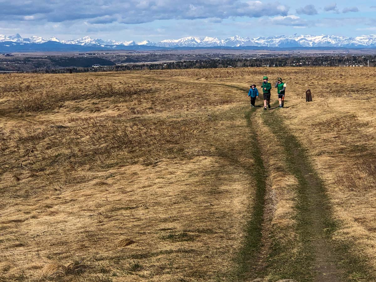 Family Kids walk along trails through Nosehill Park in Calgary Alberta Canada
