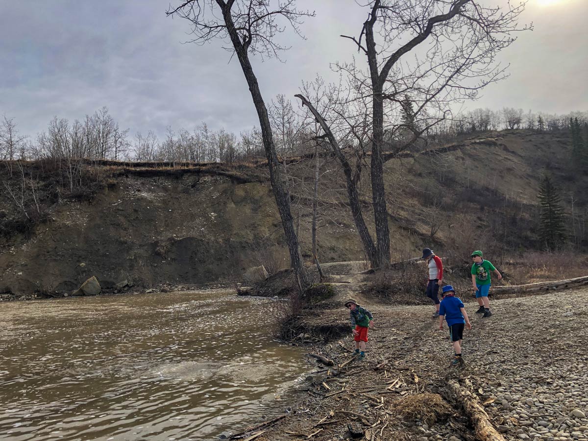 Family playing along the shores of West Fish Creek in Calgary Alberta