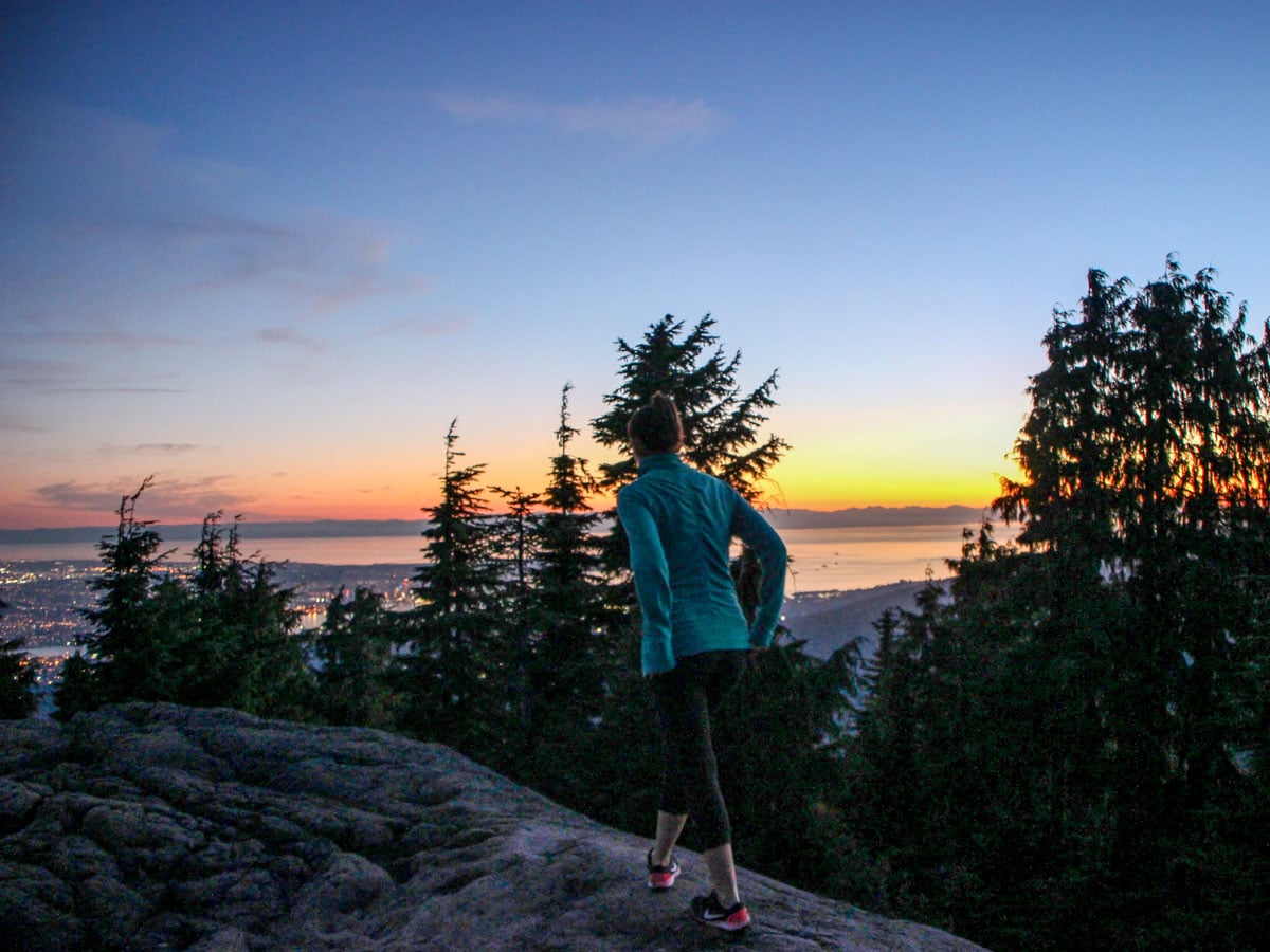 Hiker walks in the sunset on Dog Mountain peak in North Shore area of BC west coast