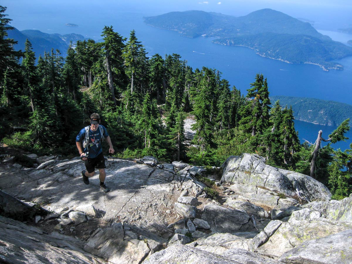 Hiker climbs the rocks of Howe Sound Crest Trial in North Shore