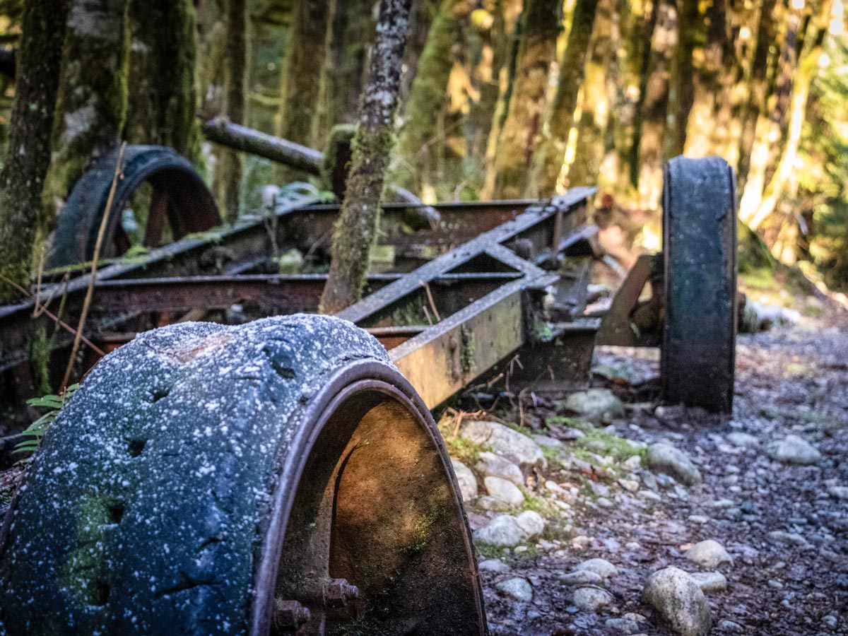 Rusted car sits in the forest along path up to Norvan Falls in North Shore area