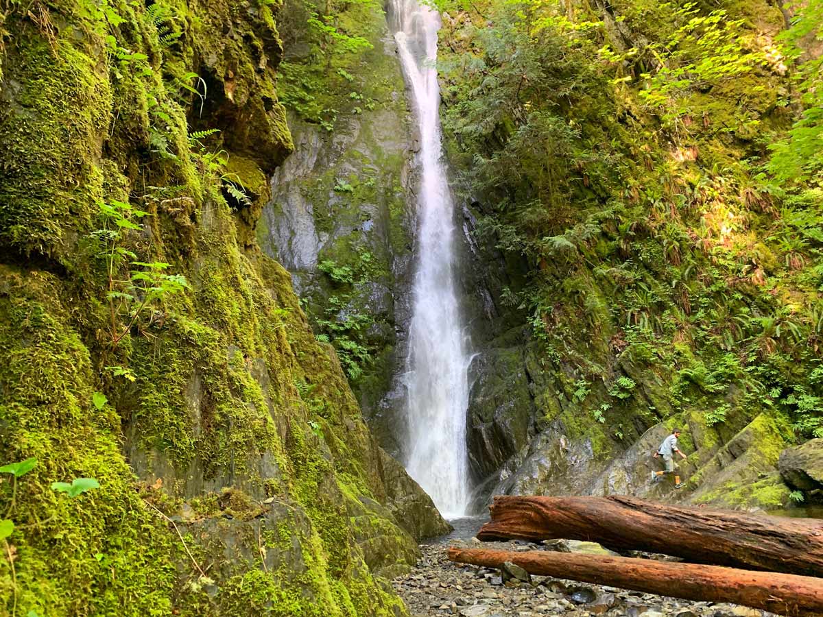 Water tumbles down mossy rock waterfalls along Goldstream to Trestle trail near Victoria