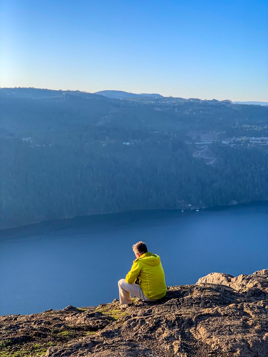Hiker watches the sun drop from Jocelyn Hill on one of the best hikes near Victoria