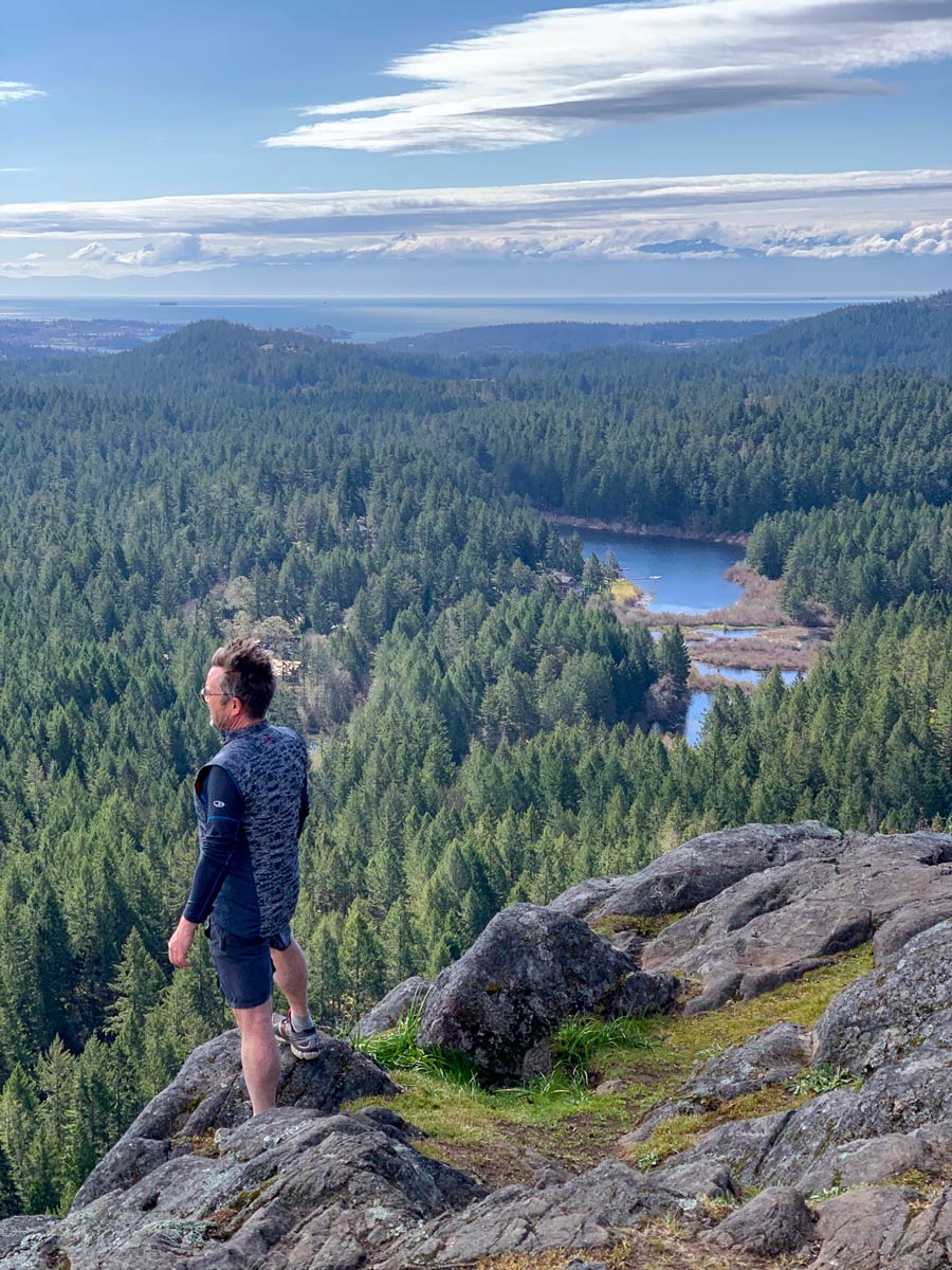 Hiker looks out on beautiful forest surrounding Thetis Lake near Victoria