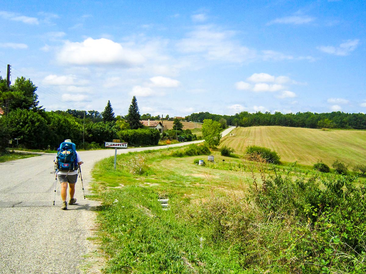 Lone hiker departing the village on Camino de Santiago French Way full trek