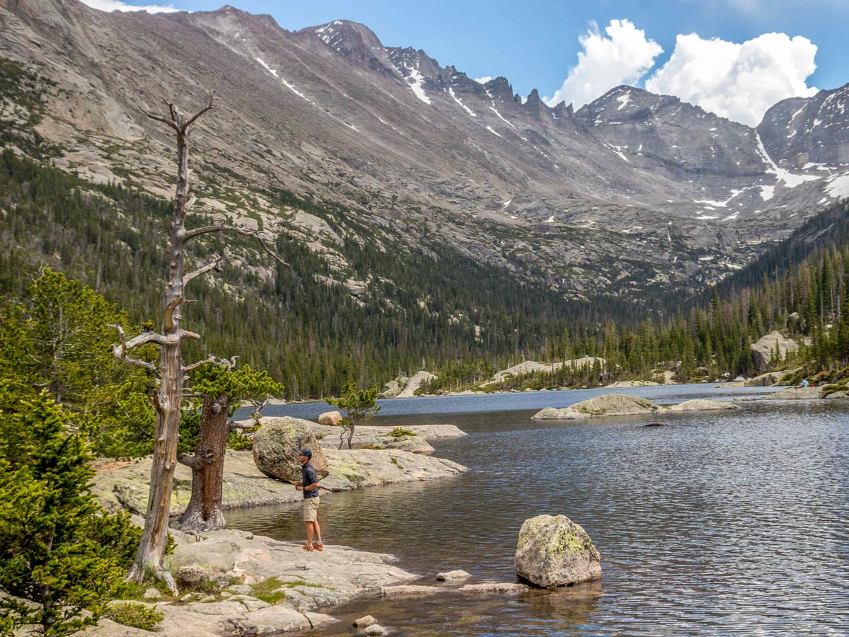 Hiker enjoys the views of Mills Lake while on one of the best hikes in Rocky Mountain National Park