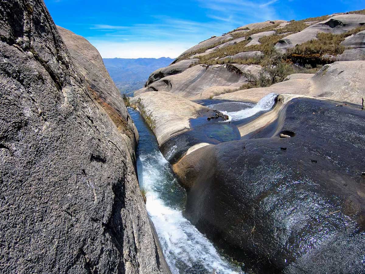 Water rushes down smooth carved rock near Lake Auquicocha