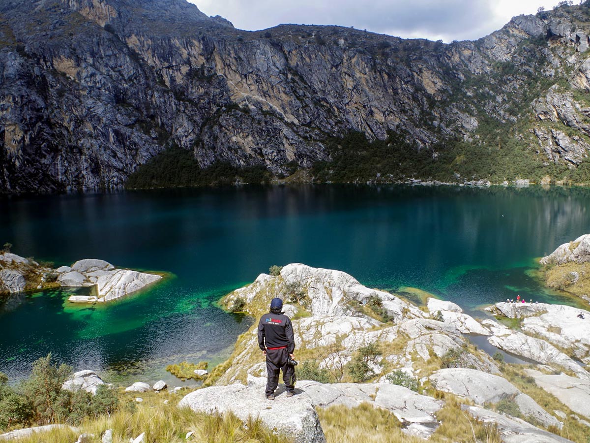 Hiker views turquois waters in Huaraz