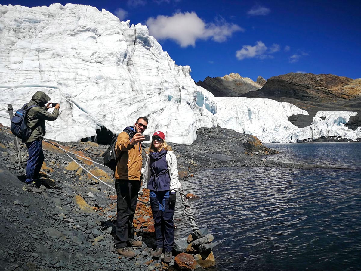 Hikers take photos by Pastoruri Glacier