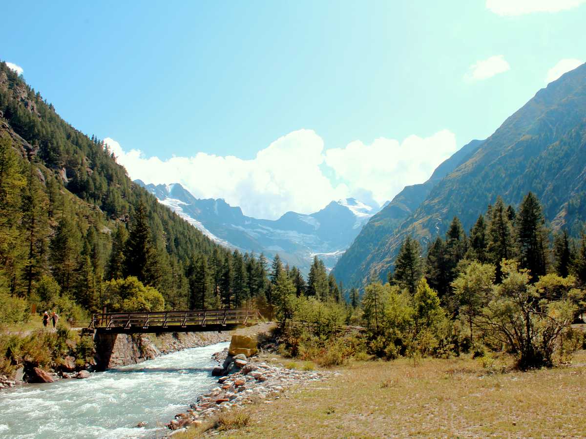 Walking along the Valnontey River with the highest peaks of Gran Paradiso National Park behind